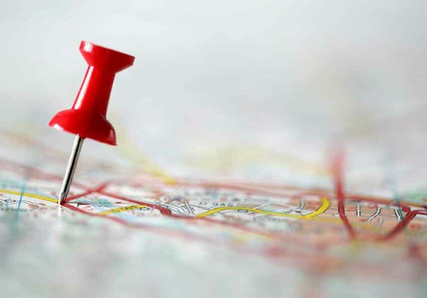 Pushpin on a map denoting a location.